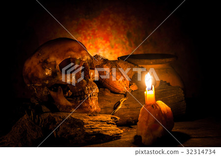 Skull and candle with candlelight on wooden Skull and candle with candlelight on wooden 32314734