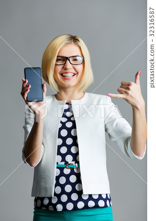 Girl with phone showing gesture Girl with phone showing gesture 32316587