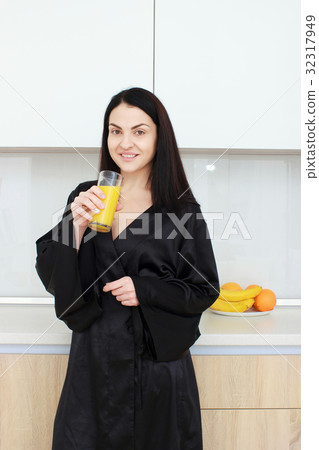 Beautiful young woman holding glass of orange 32317949
