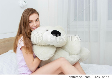 Beautiful teenager hugging soft teddy bear and 32318433