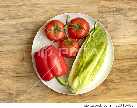 A set of vegetables lies on a white porcelain plat A set of vegetables lies on a white porcelain plat 32319402