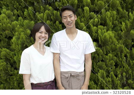 一對夫婦帶著微笑穿著放鬆穿綠色背 一對夫婦帶著微笑穿著放鬆穿綠色背 32320528