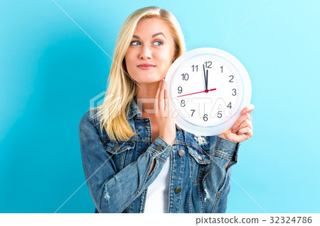 Woman holding clock showing nearly 12 Woman holding clock showing nearly 12 32324786