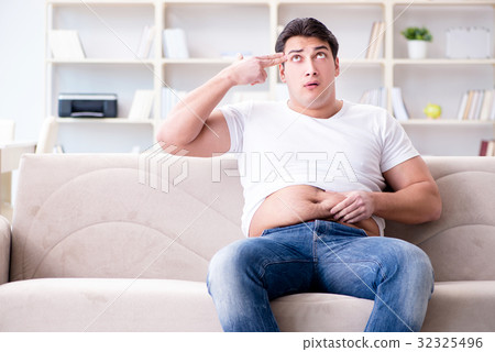 Man suffering from extra weight in diet concept 32325496