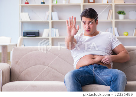 Man suffering from extra weight in diet concept Man suffering from extra weight in diet concept 32325499