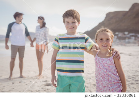 Portrait of smiling siblings with parents standing in backgeround Portrait of smiling siblings with parents standing in backgeround 32330861