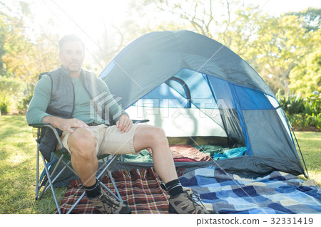 Man sitting on the chair outside the tent 32331419