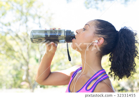 Close-up of female jogger drinking water Close-up of female jogger drinking water 32331455