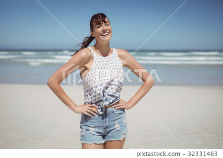 Portrait of smiling woman standing at beach 32331463