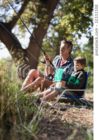 Father and son fishing in forest 32331508