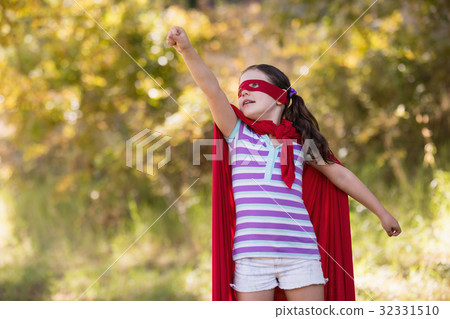 little girl trying to fly while wearing superhero costume 32331510