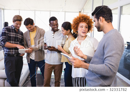 Smiling colleagues with tablet pcs in office 32331782