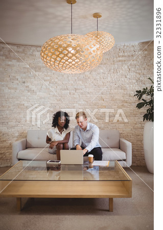 Attentive executives discussing over laptop 32331896