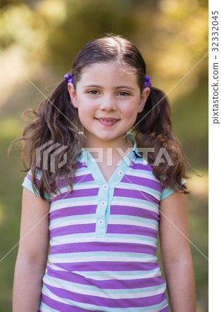 Smiling little girl standing in forest 32332045