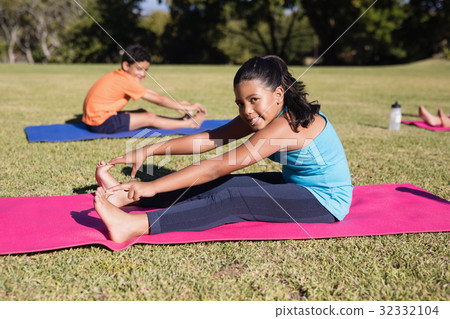Portrait of girl touching toes during yoga glass 32332104