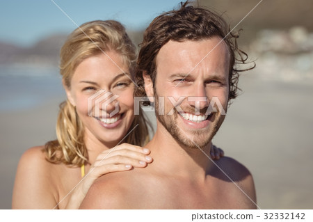 Portrait of smiling couple at beach Portrait of smiling couple at beach 32332142