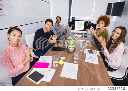 Portrait of colleagues clapping after presentation at creative office 32332318