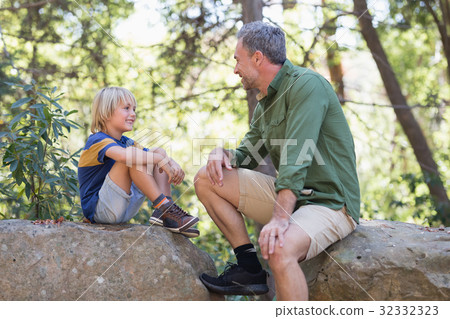 Father and talking while siting on rocks Father and talking while siting on rocks 32332323