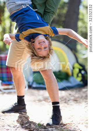 Playful father holding son upside down 32332332