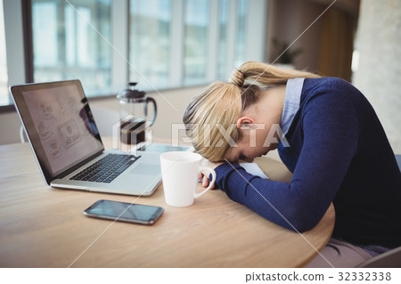 Tired businesswoman leaning on desk 32332338