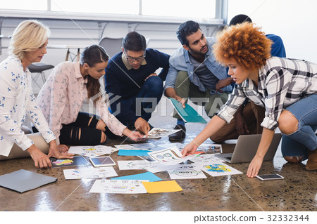 Creative business colleagues discussing over documents 32332344