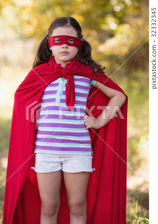 Confident little girl wearing superhero costume at campsite Confident little girl wearing superhero costume at campsite 32332345