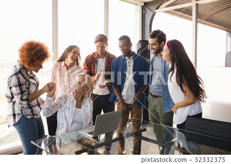Happy businesswoman with coworkers at creative office Happy businesswoman with coworkers at creative office 32332375