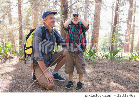 Happy man watching boy looking through binoculars Happy man watching boy looking through binoculars 32332462