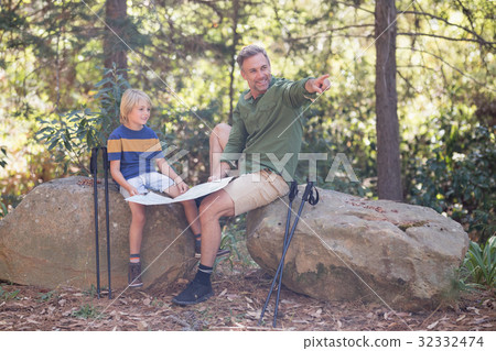 Father showing direction to son in forest Father showing direction to son in forest 32332474