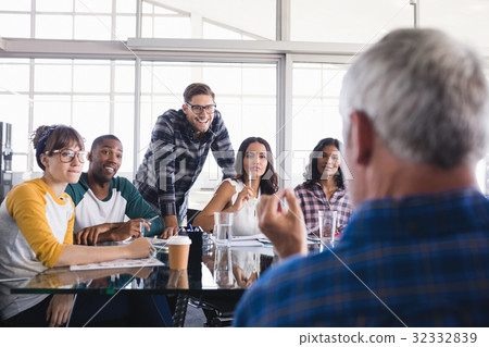 Team looking at businessman interacting with them Team looking at businessman interacting with them 32332839
