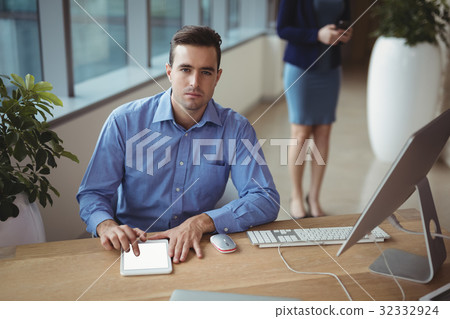 Portrait of executive using digital tablet at desk Portrait of executive using digital tablet at desk 32332924