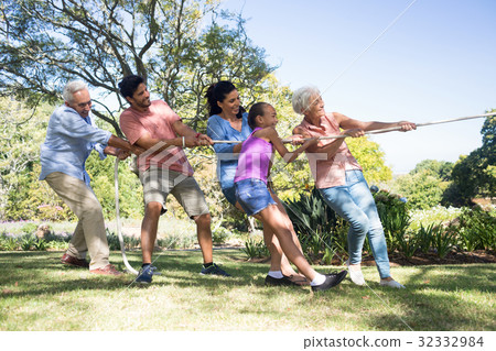 Family playing tug of war in the park 32332984