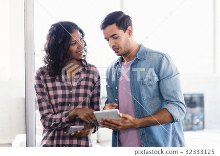 Young business colleagues discussing over digital tablet 32333125