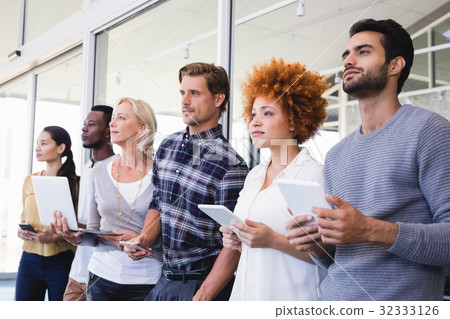 Thoughtful business people with different technologies 32333126