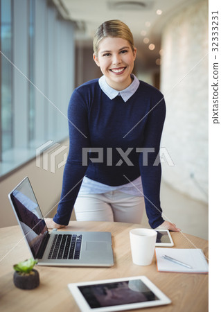 Portrait of smiling executive standing at desk 32333231