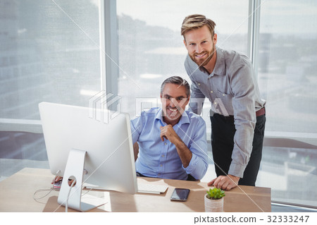 Portrait of smiling executives at desk Portrait of smiling executives at desk 32333247