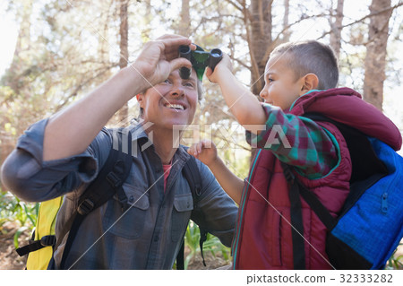 Low angle view of father and son with binoculars Low angle view of father and son with binoculars 32333282