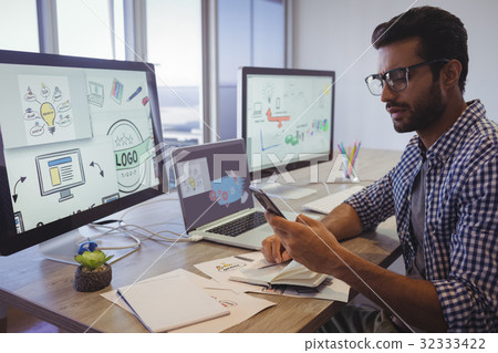Businessman using mobile phone while working in office 32333422