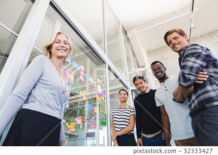 Low angle portrait of business people by plan on glass wall 32333427