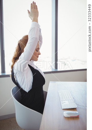 Executive exercising at desk Executive exercising at desk 32333449