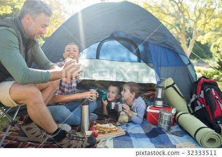 Family interacting while having snacks outside the tent 32333511