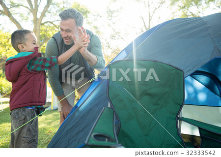 Father and son giving a high five after setting up the tent 32333542