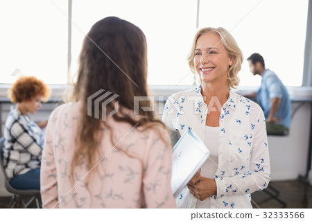 Smiling businesswoman interacting with collaeague 32333566