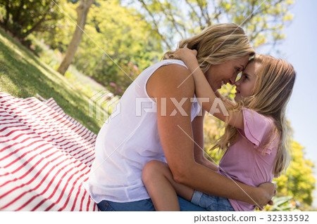 Happy mother embracing her daughter in park 32333592