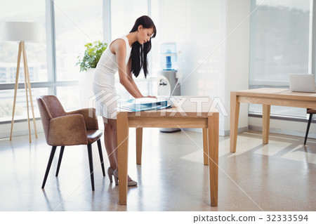 Attentive executive using laptop at desk Attentive executive using laptop at desk 32333594