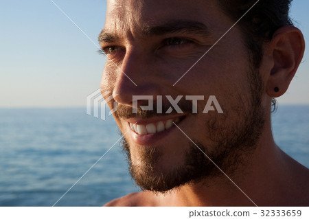 Close up of smiling man looking away at beach 32333659