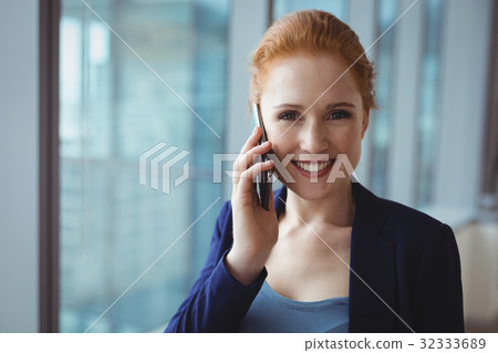Portrait of smiling executive talking on mobile phone Portrait of smiling executive talking on mobile phone 32333689