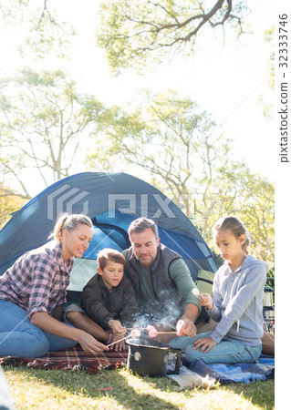 Family roasting marshmallows outside the tent Family roasting marshmallows outside the tent 32333746