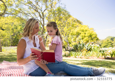 Mother and daughter reading novel in park Mother and daughter reading novel in park 32333775