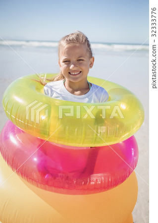 Portrait of girl standing in inflatable rings Portrait of girl standing in inflatable rings 32333776